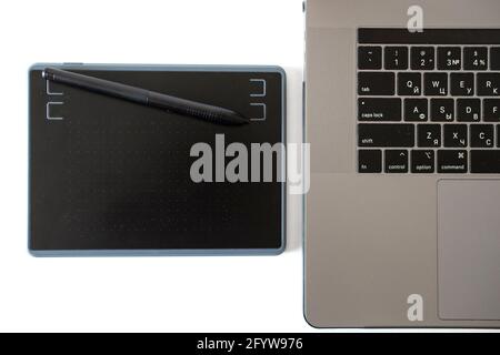 black graphics tablet with stylus and laptop. Retouching tools. Stock Photo