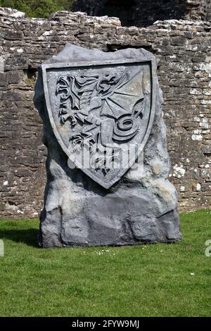 A large rock with the emblem of Wales emblazoned on it set up inside the grounds of Ogmore castle ruins near Bridgend. Stock Photo