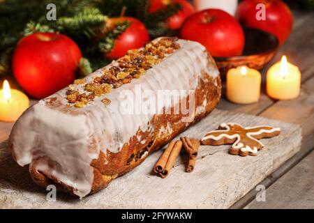 Christmas poppy seed cake and gingerbread cookie in bird shape. Candles and apples around - traditional decoration Stock Photo