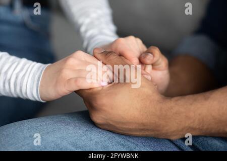 Cropped Image Of Romantic Interracial Couple Holding Hands Together Stock Photo