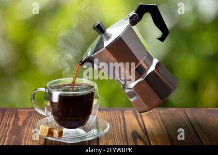 espresso pouring from flying geyser coffee maker into cup Stock Photo