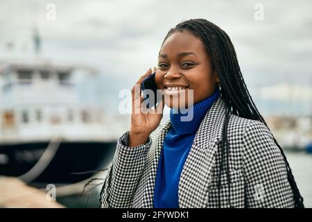 Young african american businesswoman smiling happy talking on the smartphone at the port. Stock Photo