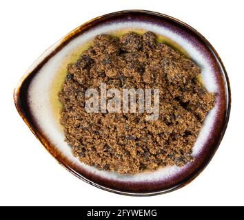 top view of muscovado dark brown cane sugar in ceramic bowl isolated on white background Stock Photo