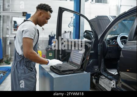 Male mechanic using laptop, car service Stock Photo