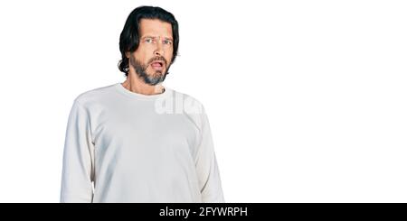 Middle age caucasian man wearing casual clothes in shock face, looking skeptical and sarcastic, surprised with open mouth Stock Photo