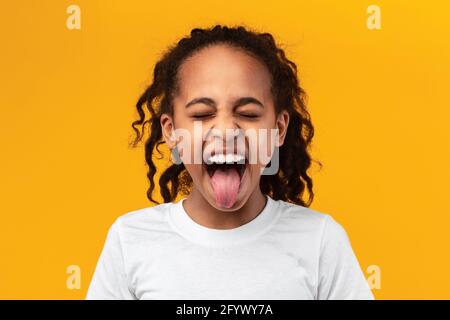 Naughty black teenage girl sticking out her tongue Stock Photo
