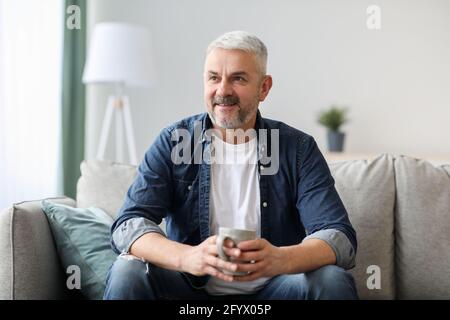 Happy old man with mug looking at copy space Stock Photo