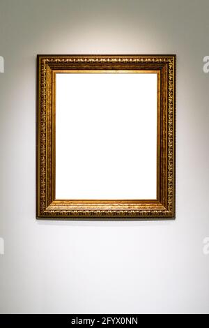 old vertical classic wide golden picture frame with cutout canvas on gray wall Stock Photo