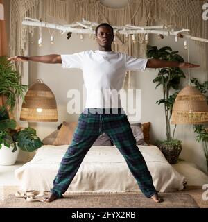 African man working out, yoga, pilates, fitness training, basic standing asana tadasana, mountain yoga posture Stock Photo