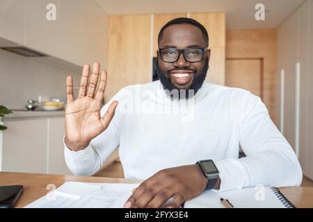 Headshot portrait of young african amercian man saying hi smiling to camera Stock Photo