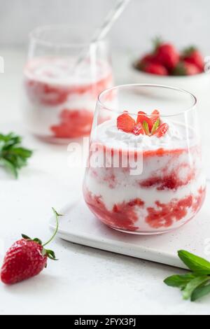 Strawberry shake with coconut milk served with slices of fresh strawberries and mint leaves. Healthy food and drink concept. vertical image