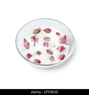 Dried rose buds in a glass cup with white sugar to obtain the rose taste and odor isolated on white background Stock Photo