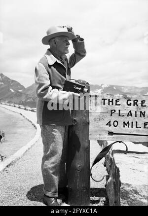 Burton Holmes Holding Movie Camera Next to Great Plains Sign, Estes Park, Colorado, ca 1930 Stock Photo