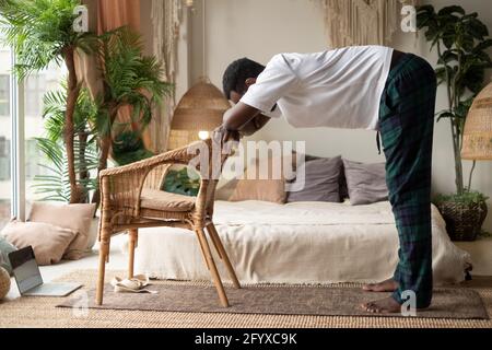 African young man working out, practicing yoga, standing in Ardha Uttanasana Stock Photo