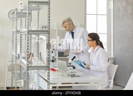 Two diverse scientist conducting experiment in modern chemistry laboratory Stock Photo