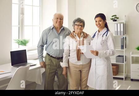 Happy smiling elderly senior couple and female doctor posing for camera Stock Photo