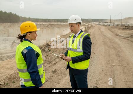 Young contractor with tablet talking to female builder Stock Photo