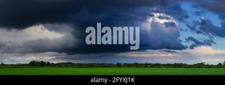 Dramatic clouds, field and sky with dark clouds Stock Photo