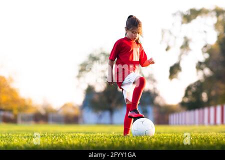 Girl kicks a soccer ball on a soccer field Stock Photo