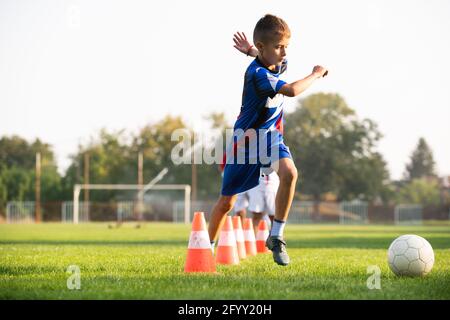Boys passes soccer ball each other on the football field. Stock Photo