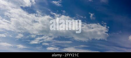 Landscape of blue sky with blurred clouds floating brightly across the sky on a clear sunny day Stock Photo