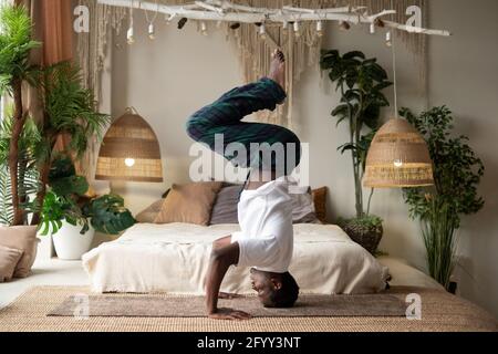 Young african fitness sportsman in yoga position on head working Stock Photo