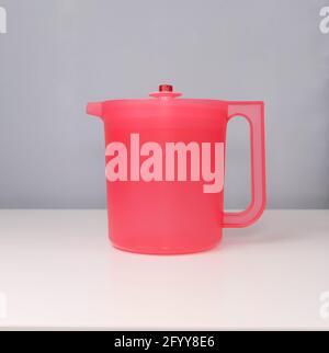 Red water jug isolated on a grey and white background Stock Photo