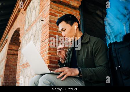 Happy young African American female student in casual outfit lying on comfortable bed and reading book at home Stock Photo