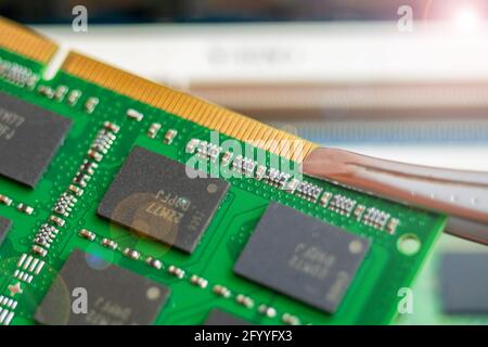 Master holds with tweezers Laptop RAM close up Stock Photo