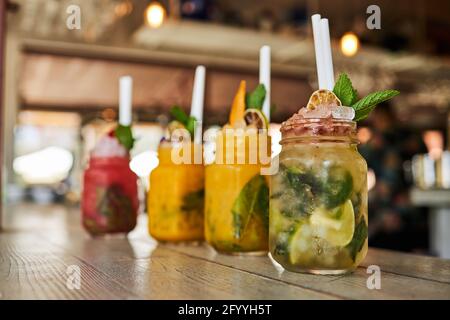 Set of refreshing various mojito cocktails including strawberry peach and classic flavors served on table in bar Stock Photo
