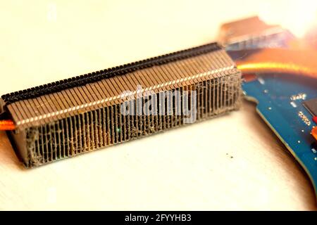 Dusty heatsink on laptop motherboard, removing dust in computer cooling system Stock Photo