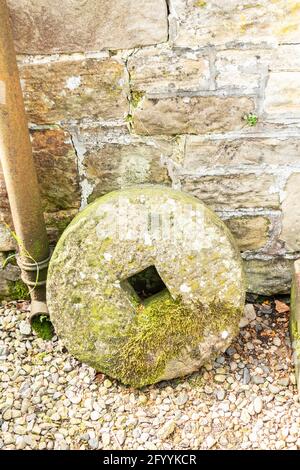 old millstone against stone wall at Hadrian's Wall Northumberland Stock Photo