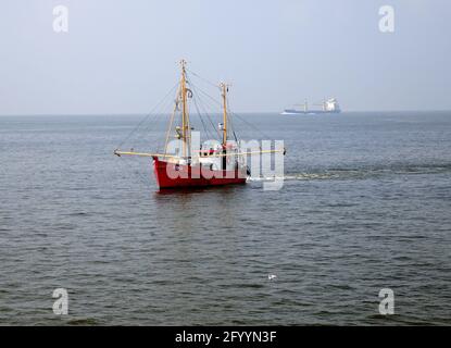Small Red Fish Trawler Fishing In The North Sea On A Hazy And Sunny Summer Day Stock Photo