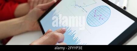 Businessman holding tablet with charts and diagrams in his hands at workplace Stock Photo