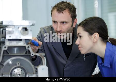 instructor with trainees working on car engine Stock Photo