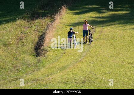 Two girls on mtb bikes. Mother and daughter riding on a trail. Stock Photo