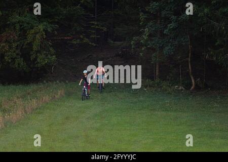 Two girls on mtb bikes. Mother and daughter riding on a trail. Stock Photo