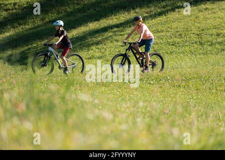 Two girls on mtb bikes. Mother and daughter riding on a trail. Stock Photo