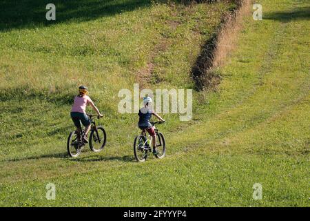 Two girls on mtb bikes. Mother and daughter riding on a trail. Stock Photo