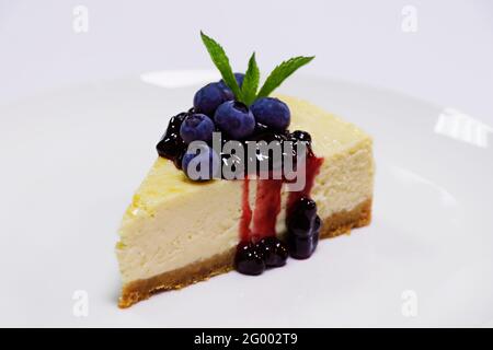 baked new york style vanilla cheesecake with berries in a white plate Stock Photo