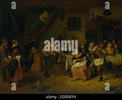 Peasant Wedding. A farm house is celebrated in an inn. At a table, the bride is surrounded by men, on the wall behind her hangs a tapestry. The groom sits on the left of her and drinks his glass. In the foreground an old man dances on music from musicians with violin and cello. Left watch a standing man and woman. Egg shells, bones, a plate and a spoon are lying on the floor. Stock Photo