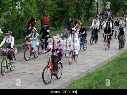 Kiev, Ukraine. 30th May, 2021. Participants wearing vintage outfits take part during a retro cycle parade in Kiev.The annual spring retro cycle parade which is held in the center of the Ukrainian capital brings together fans of retro style, some dressed in vintage attires of the first half of the twentieth century, who attend the bike ride, a picnic, a jazz concert and a vintage fair. Credit: SOPA Images Limited/Alamy Live News Stock Photo