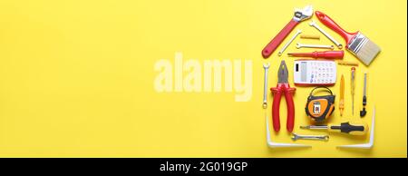 House shape made with calculator and construction tools on color background with space for text Stock Photo