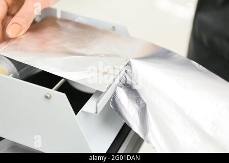 Professional hairdresser with coloring foil, closeup Stock Photo