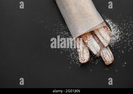 Tasty churros in parchment on dark background Stock Photo