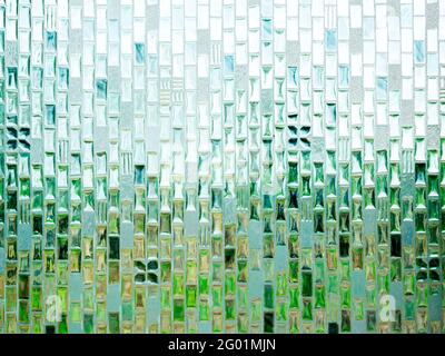 Close-up abstract seamless pattern texture of translucent bathroom glass window with the light and abstract natural green from outside. Stock Photo