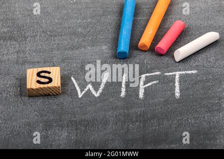 Riga, Latvia - May 10 ,2021: Swift code and programming language concept. Colored chalk pieces on a black chalk board Stock Photo