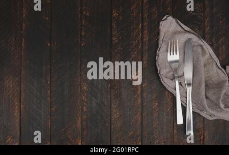 Cutlery and napkin on wooden background, top view. Table setting, food concept stylish table setting cutlery on white table with silver fork and knife Stock Photo