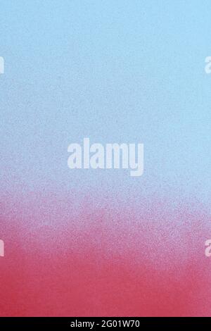 redspray paint on a soft blue colored paper background Stock Photo