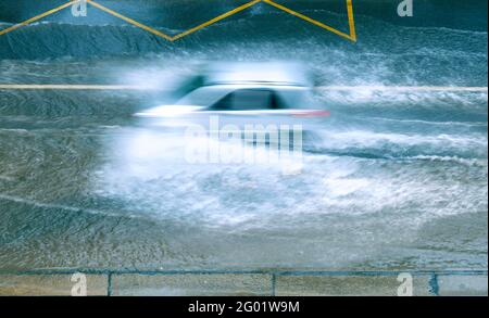 Heavy flood in the city, car motion with fast speed on the big puddle Stock Photo